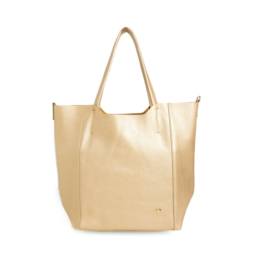 Parker Tote Leather Bag - Gold by Nataly Mendez, Genuine leather 21" H, 6.5" D Top: 9.5" W, Bottom: 13" W Handle Drop: 8.5"; Hook closure Flat zipped inside pocket Gold-color hardware Gold heart