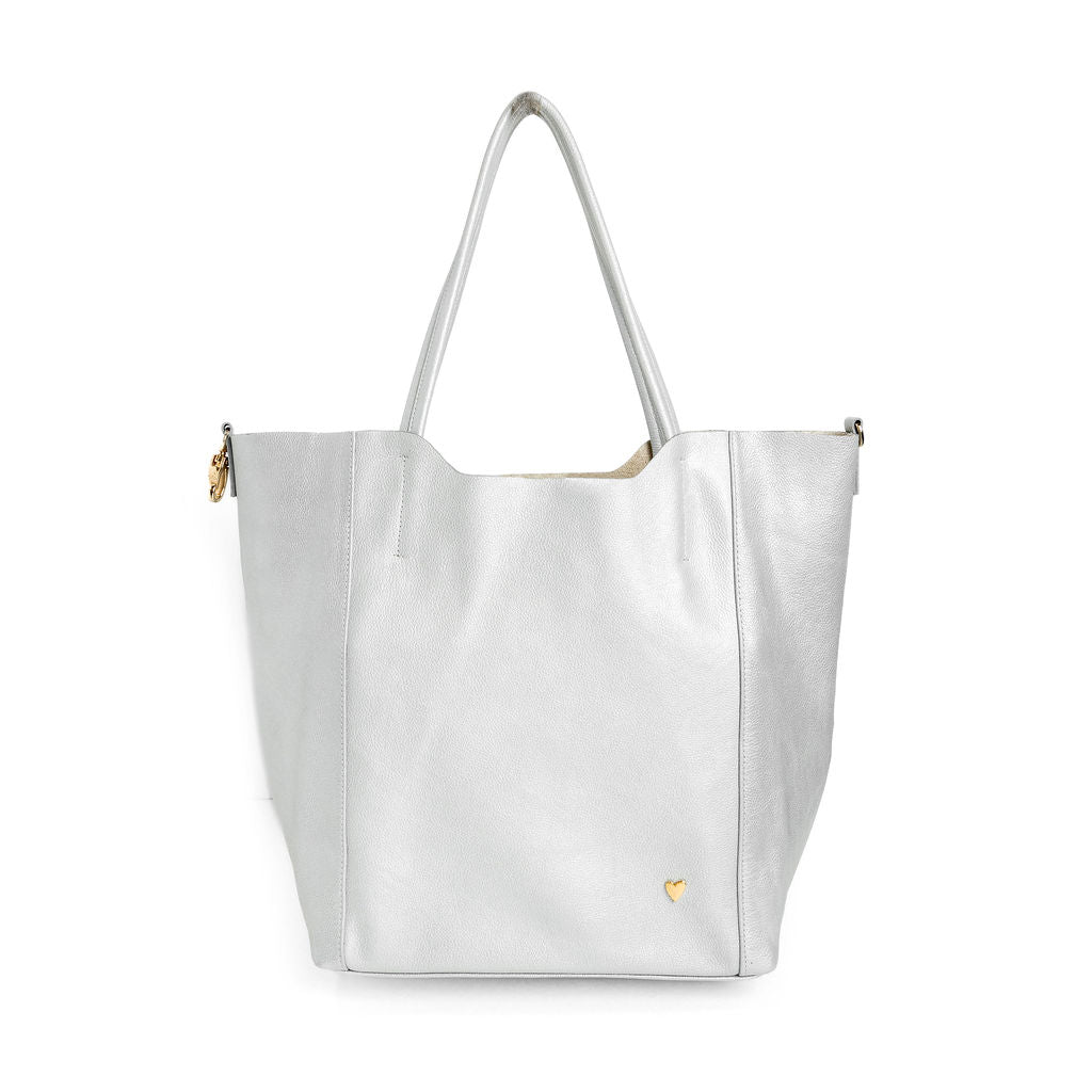 Parker Tote Leather Bag - Silver by Nataly Mendez, Genuine leather 21" H, 6.5" D Top: 9.5" W, Bottom: 13" W Handle Drop: 8.5", Hook closure Flat zipped inside pocket Gold-color hardware Gold heart