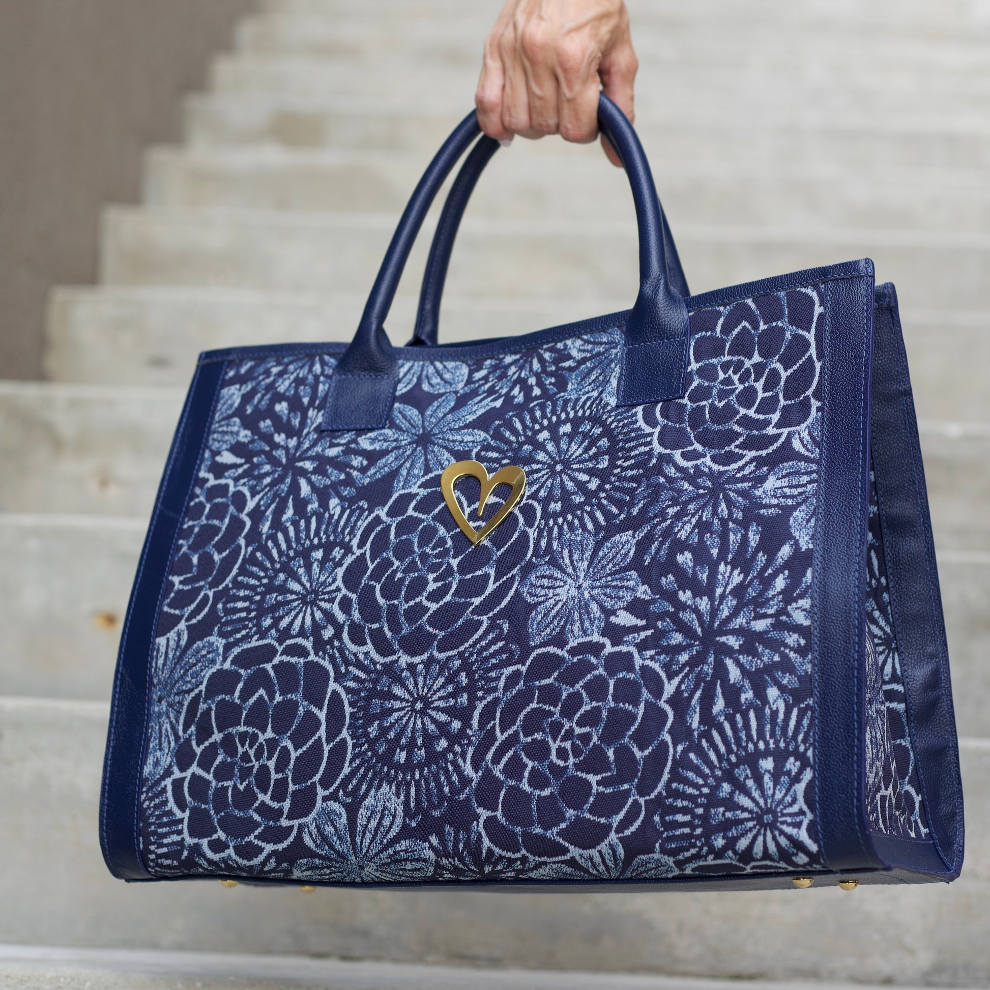 Sienna Tote Bag - Blue Flowers by Nataly Mendez, Genuine leather Fabric lining 16 x 12 x 7.5 inches (Length x Height x Width)  Handle Drop: 6"&nbsp; Magnetic snap closure Two inside pockets Gold heart