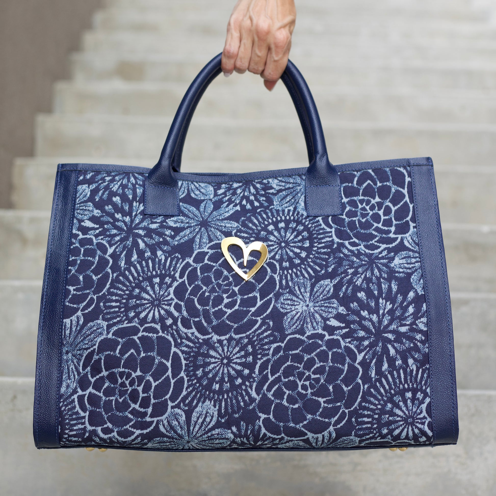 Sienna Tote Bag - Blue Flowers by Nataly Mendez, Genuine leather Fabric lining 16 x 12 x 7.5 inches (Length x Height x Width)  Handle Drop: 6"&nbsp; Magnetic snap closure Two inside pockets Gold heart