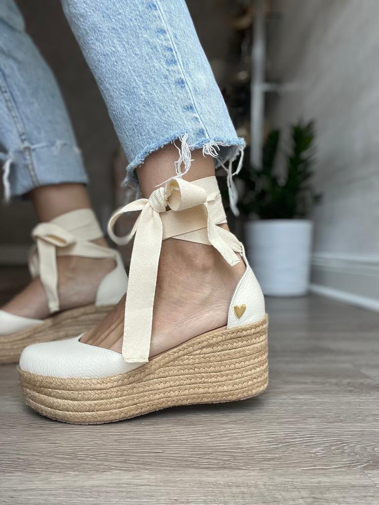 White Espadrilles Low High by Nataly Mendez. Natural jute base Genuine leather upper Genuine leather insole. 100% made in Colombia! 3 inch heel height 1.75 inch platform Comes with strap closure and beige hiladilla laces.